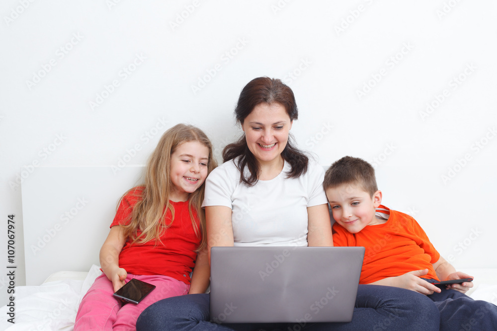 kids with smartphones watching at mom's laptop kids with smartphones watching at mom's laptop