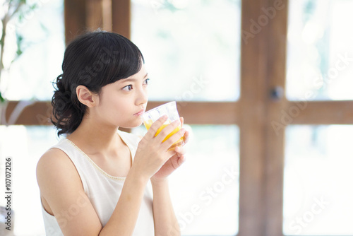 オレンジジュースを飲む女性