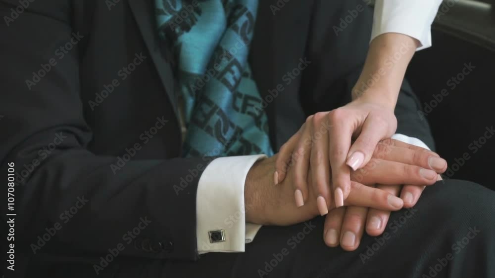 Girl's hand is placed on the arm of a young man Girl's hand is placed on the arm of a young man