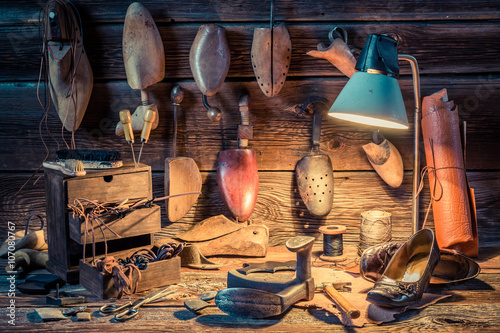 Shoemaker workshop with tools, shoes and laces photo