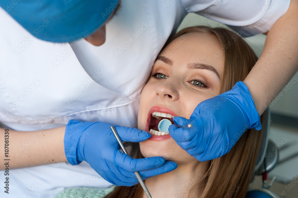 Dentist examining a patient's teeth Dentist examining a patient's teeth