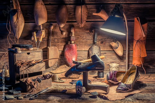 Vintage shoemaker workplace with brush and shoes