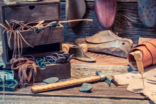 Old shoemaker workshop with brush and shoes photo