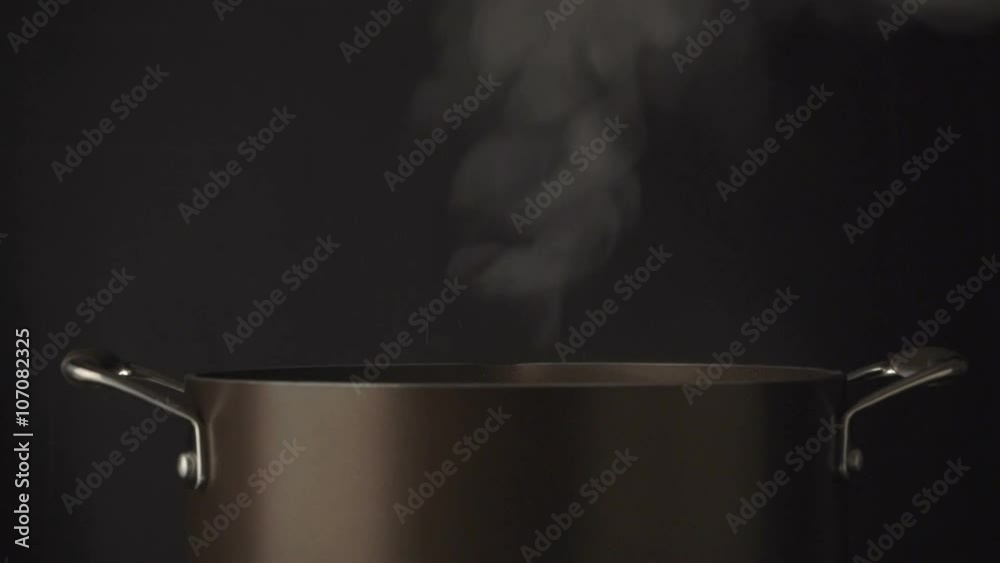 Hand open lid on steaming pot