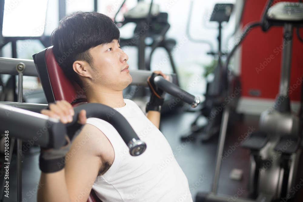 young handsome asian man works out in modern gym young handsome asian man works out in modern gym