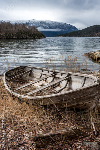Old wooden boat on the shore of an Norwegian fjord