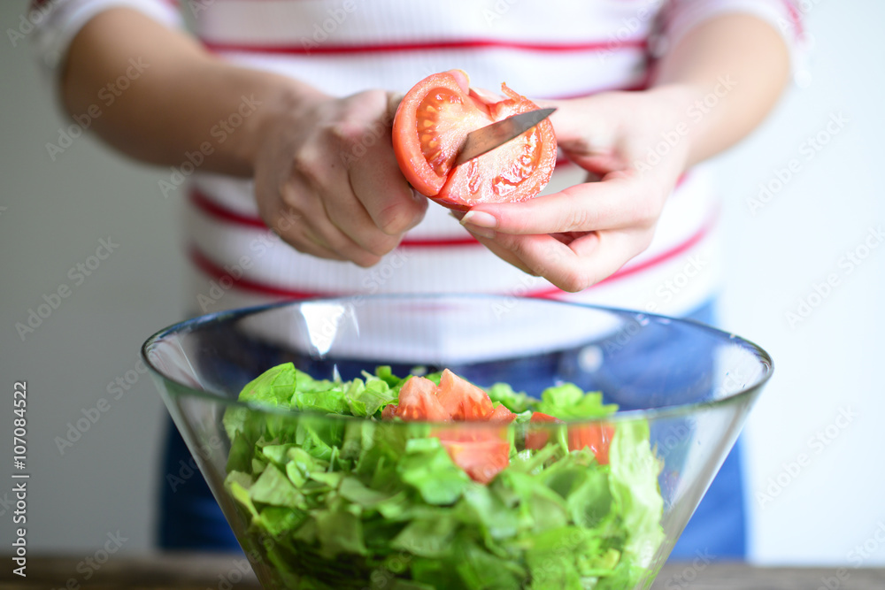 Woman hand cut tomato for salad