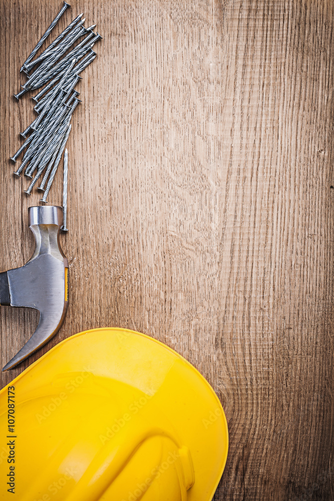 Fototapeta premium Claw hammer metal construction nails building helmet on wooden b