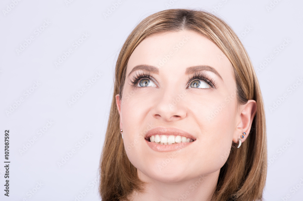 Closeup portrait of a smiling girl. The gaze is directed upwards Closeup portrait of a smiling girl. The gaze is directed upwards