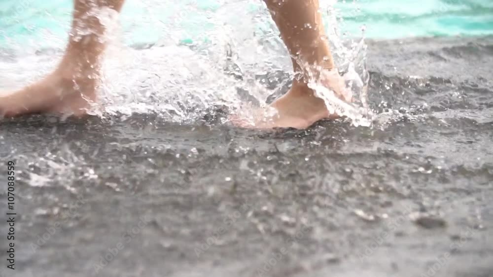 Slow motion shoot of feet walking by pool . Little child walking near swimming pool Slow motion shoot of feet walking by pool . Little child walking near swimming pool