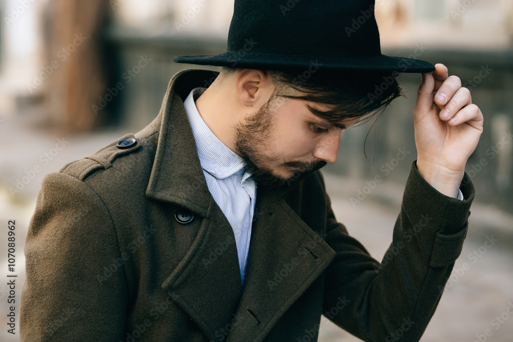 handsome young bearded hipster man guy in hat Fedora on street with  suitcase. Retro vintage fashion look Stock Photo | Adobe Stock