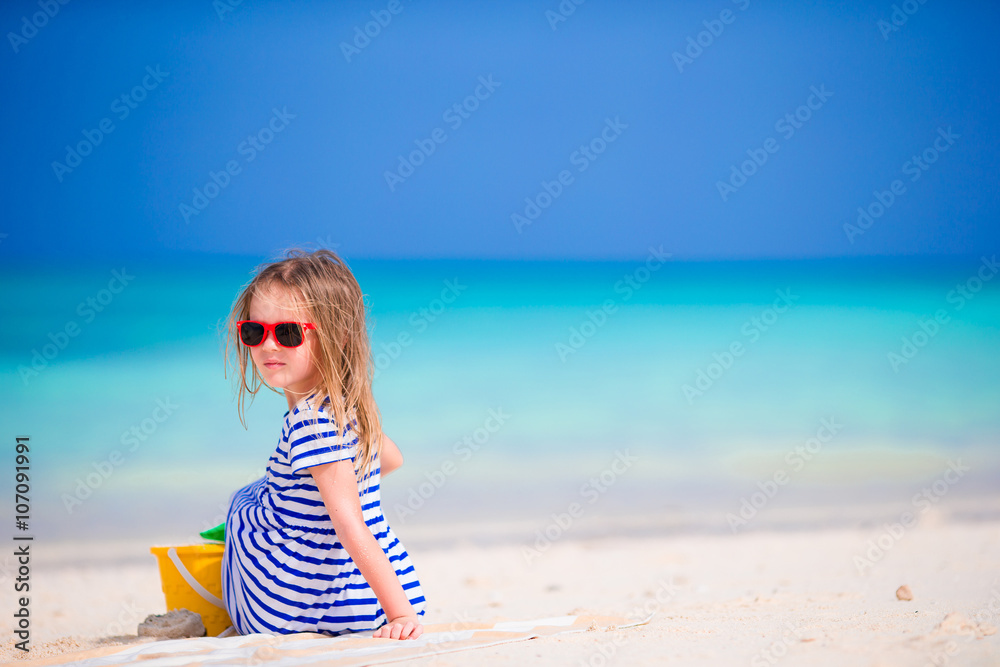Adorable little girl playing with beach toys during tropical vacation Adorable little girl playing with beach toys during tropical vacation