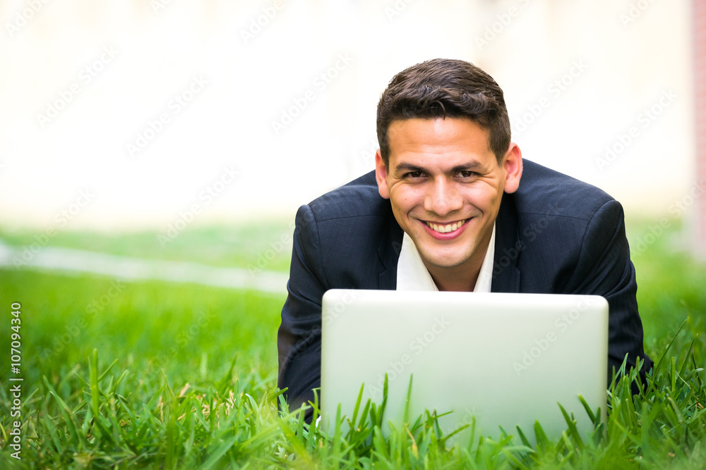 Young happy man working with his laptop outside Young happy man working with his laptop outside