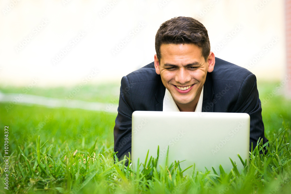 Young happy man working with his laptop outside Young happy man working with his laptop outside