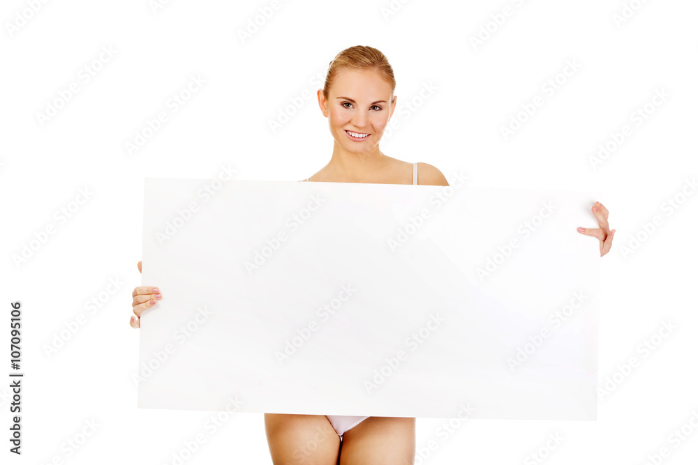 Sexy young woman holding empty board 