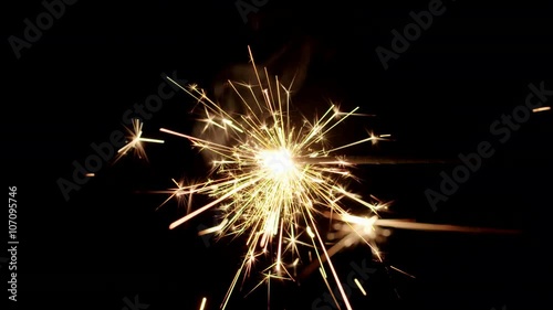 Sparkler burning from left to right in center of black background.  Recorded in 4K at 60fps.