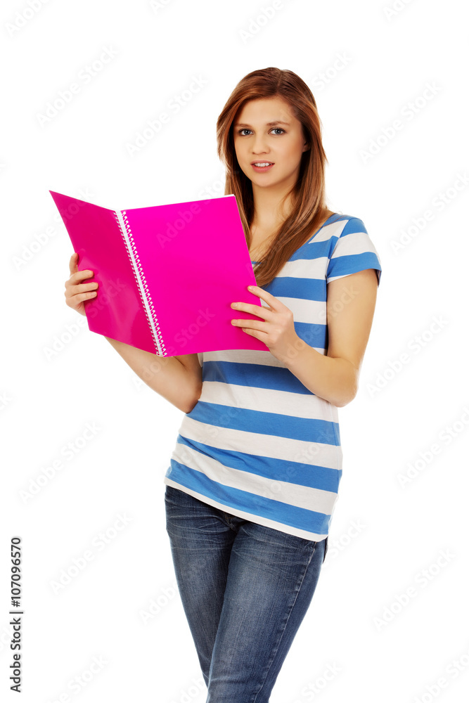 Smiling teenage woman reading her notes Smiling teenage woman reading her notes