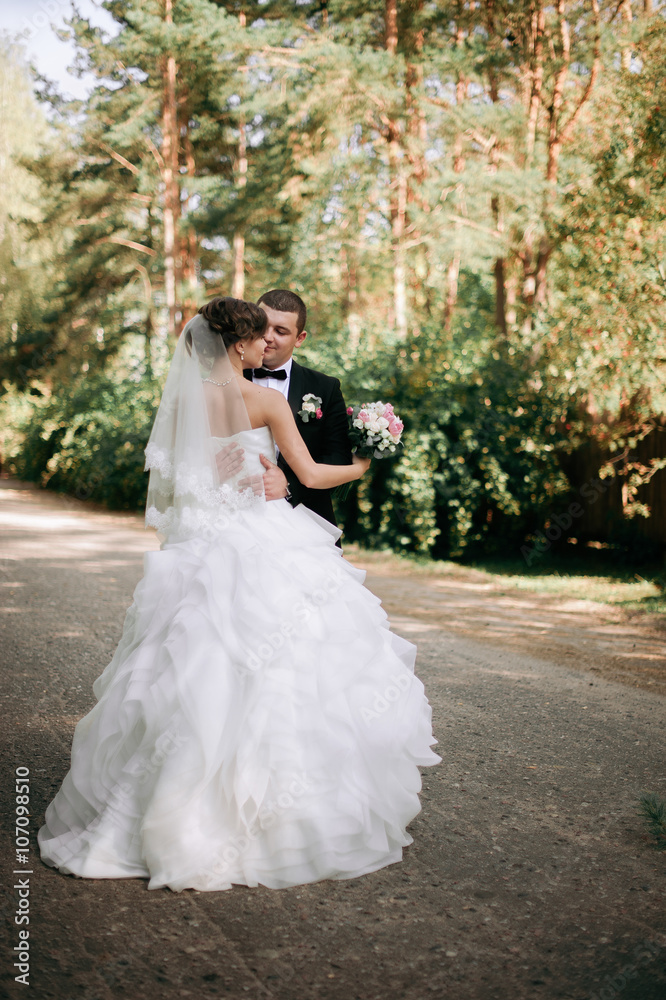 Elegant young happy wedding couple is sitting at green grass on Elegant young happy wedding couple is sitting at green grass on