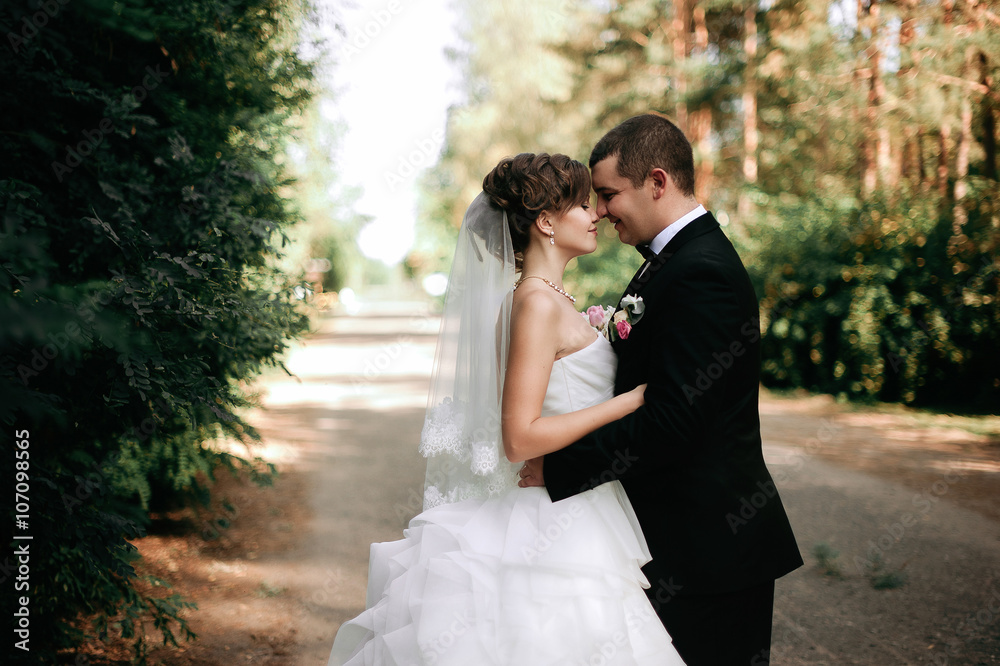Elegant young happy wedding couple is sitting at green grass on Elegant young happy wedding couple is sitting at green grass on