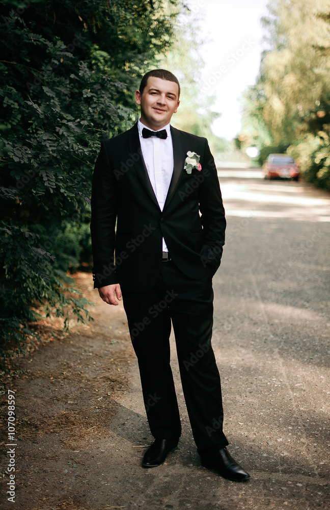 wedding day. Groom is staying and waking wearing black classic c wedding day. Groom is staying and waking wearing black classic c