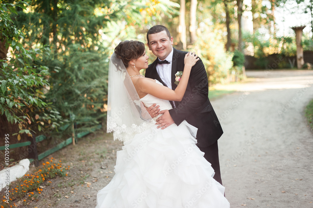 Elegant young happy wedding couple is sitting at green grass on Elegant young happy wedding couple is sitting at green grass on
