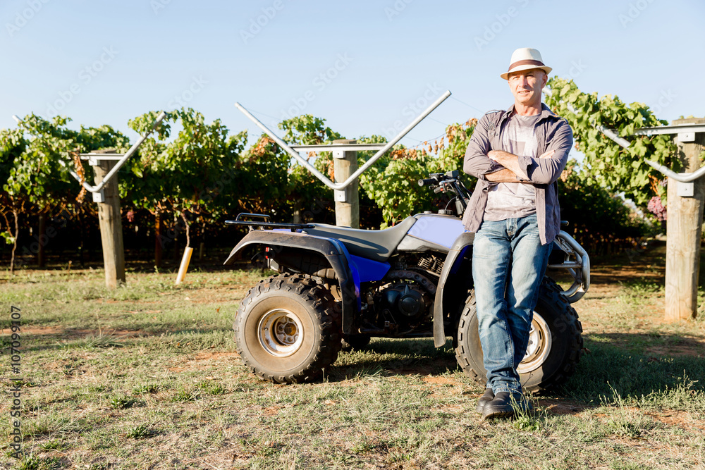 Obraz premium Man standing next to truck in vineyard