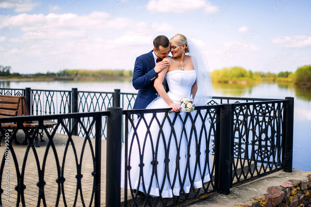 happy and beautiful groom and bride tender kiss at spring outdoo happy and beautiful groom and bride tender kiss at spring outdoo