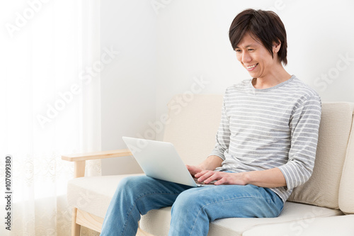 young asian man using laptop computer