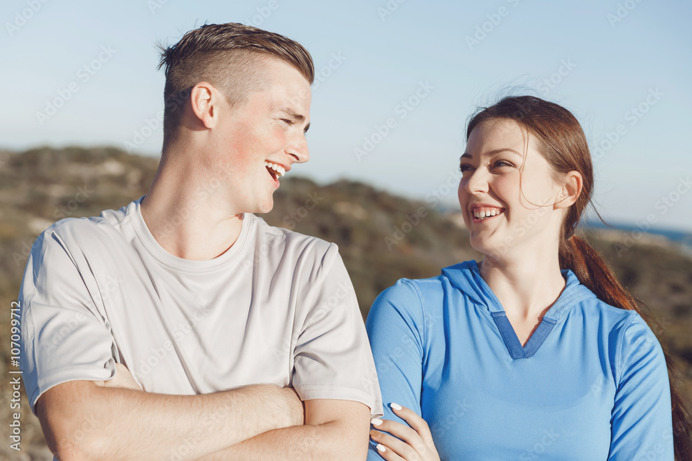 Young couple on beach in sportwear Young couple on beach in sportwear
