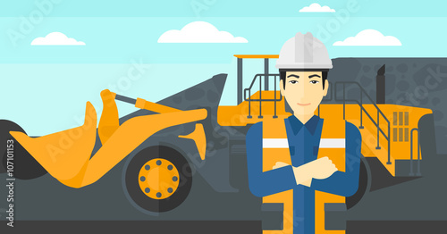 Miner with mining equipment on background.