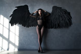 Fallen black angel with wings. Sexual woman