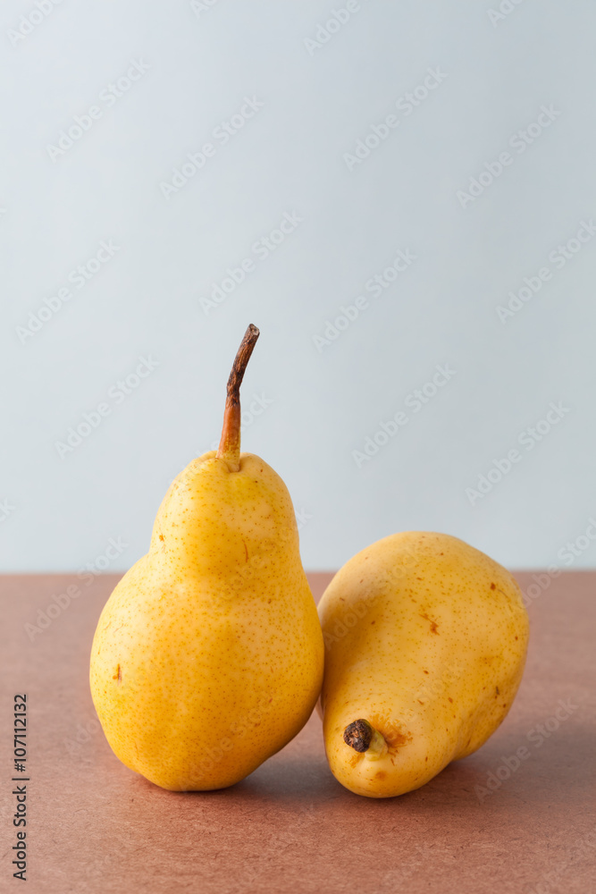Two whole yellow Corella pears on wooden surface. Vertical image with copy space. Two whole yellow Corella pears on wooden surface. Vertical image with copy space.