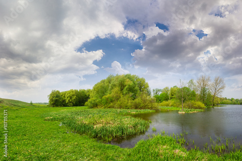 Fototapeta Naklejka Na Ścianę i Meble -  Spring landscape with lake, meadow, forest and sky with clouds
