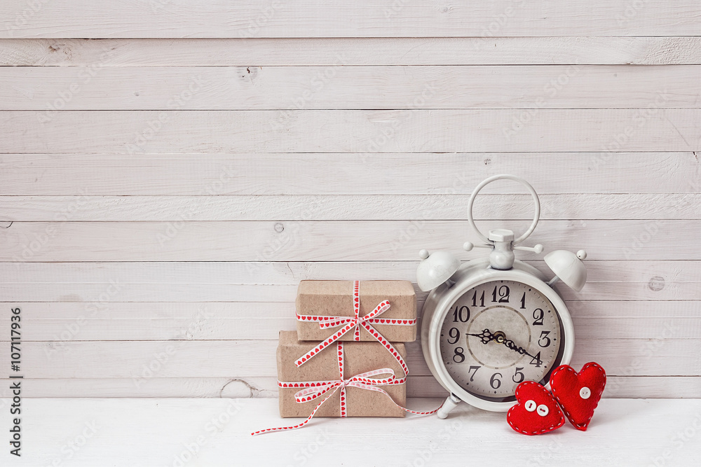 Background with white alarm clock, gift boxes and red hearts on Background with white alarm clock, gift boxes and red hearts on