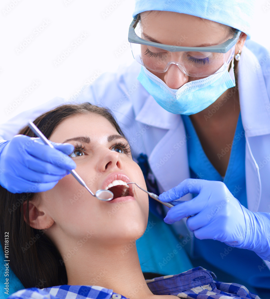 Woman dentist working at her patients teeth