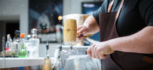 Bartender breaks ice with wooden hammer