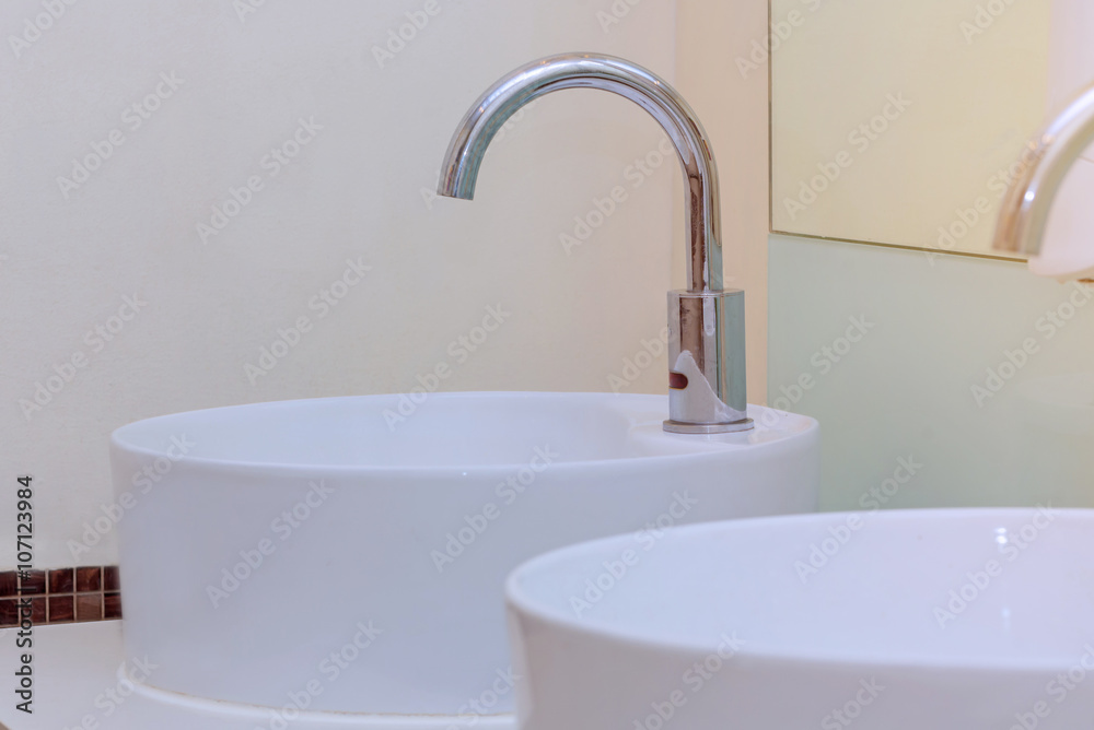 white basins in bathroom interior with granitic tiles