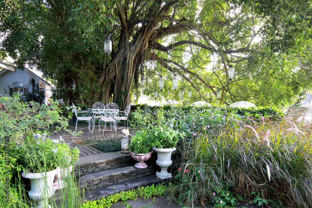 White wrought iron chair and table in garden in the morning White wrought iron chair and table in garden in the morning