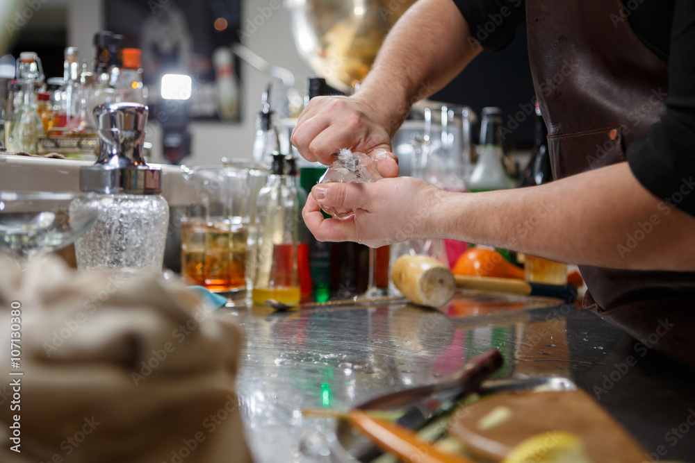Fototapeta premium Bartender pours alcoholic drink into small glasses with flames