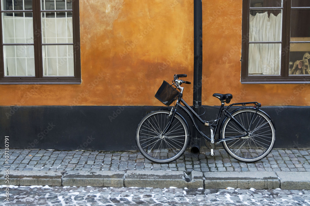 Black bike with basket on  red wall, Stockholm , Sweden