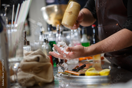 Canvas Print Bartender pours alcoholic drink into small glasses with flames