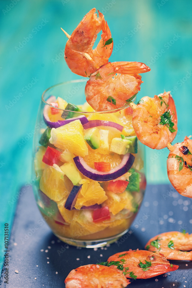 Grilled shrimps on skewers with salad 
