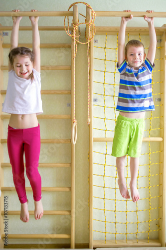 Kids playing and hanging on horizontal bar
