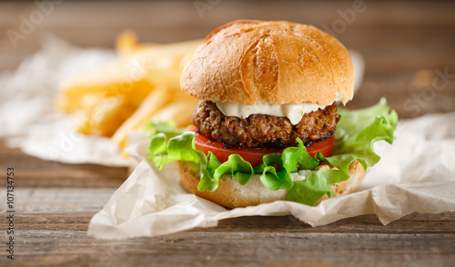 Homemade burger with french fries on wooden table