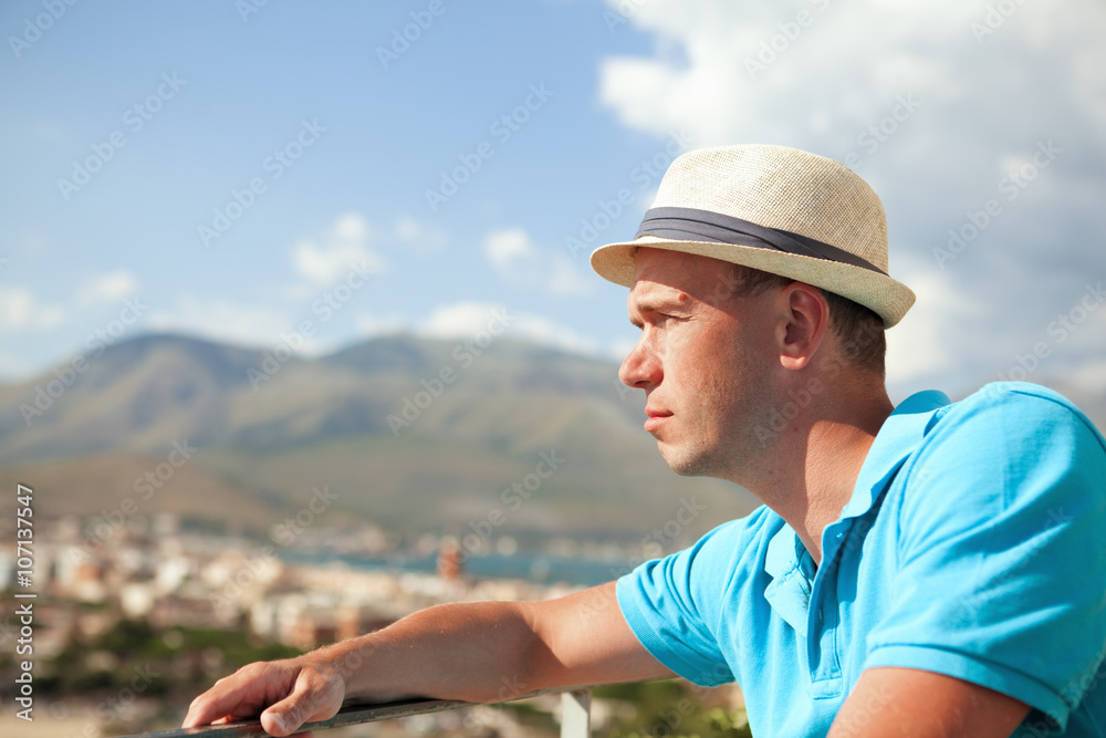 Portrait of man with hat on background of mountains, Italy