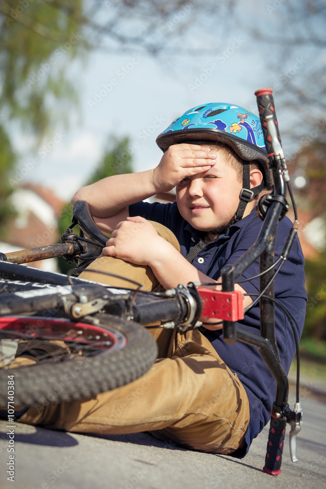 Naklejka premium Boy fell from the bike in a park