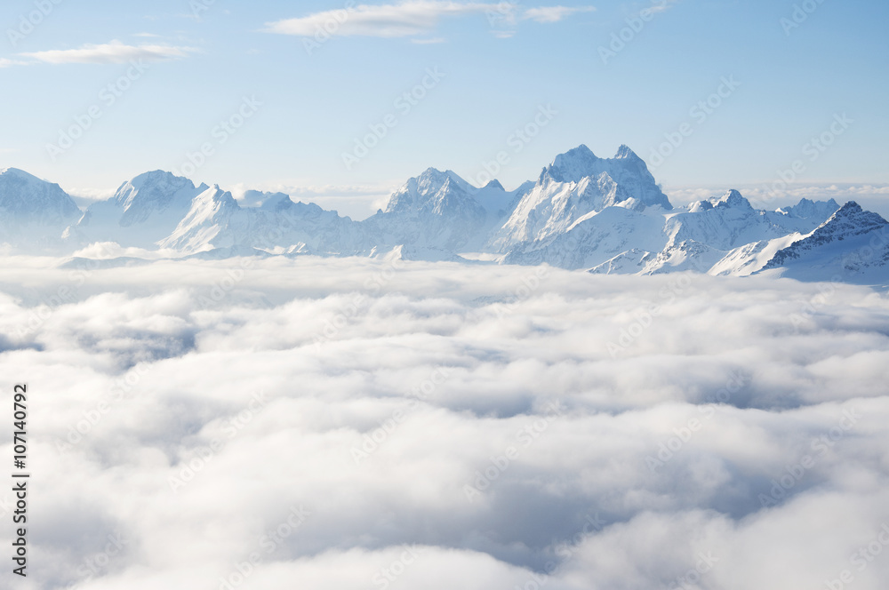 Sharp mountain peaks sticking out of clouds Sharp mountain peaks sticking out of clouds