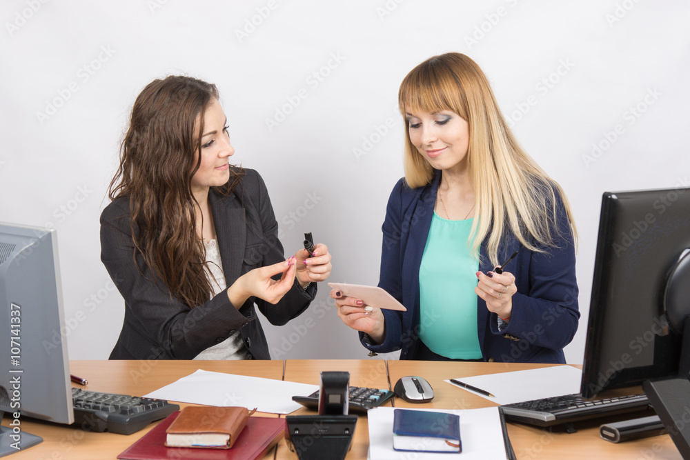 Office workers enthusiastically share the secrets of make-up with each other Office workers enthusiastically share the secrets of make-up with each other
