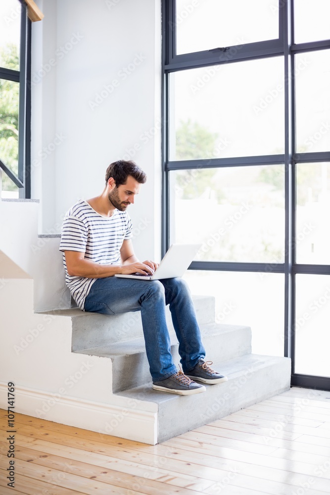 Happy man sitting on steps using laptop Happy man sitting on steps using laptop