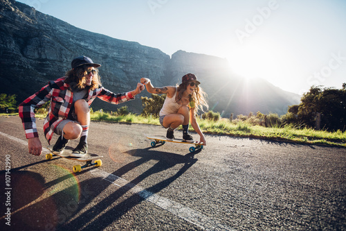 Couple having fun with skateboard on the road
